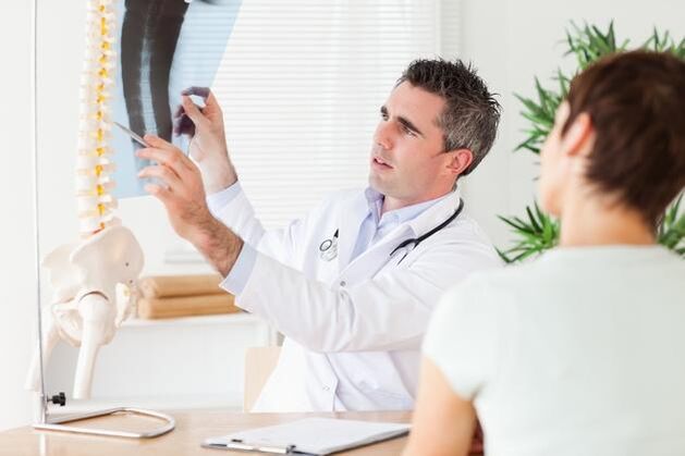 лекарят показва увреждане на гръбначния стълб поради цервикална остеохондроза